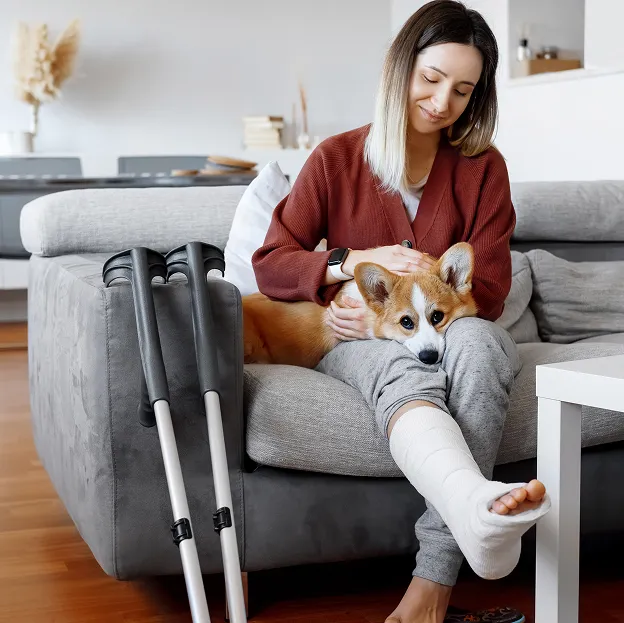 femme assise sur un canapé avec un plâtre à la jambe à Mas-Grenier dans le Tarn-et-Garonne 82